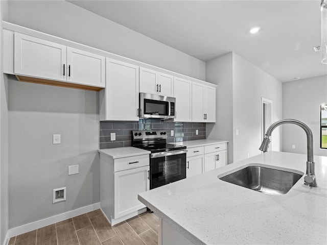 kitchen featuring stainless steel appliances, white cabinets, sink, and light hardwood / wood-style flooring