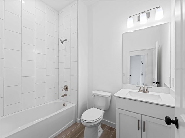 full bathroom featuring hardwood / wood-style floors, tiled shower / bath, toilet, and vanity