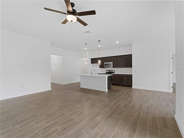 unfurnished living room with ceiling fan, sink, and light hardwood / wood-style flooring