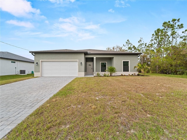 view of front of house with a garage, central AC, and a front lawn