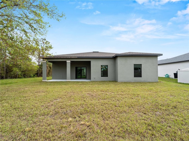 back of property featuring a lawn and a patio