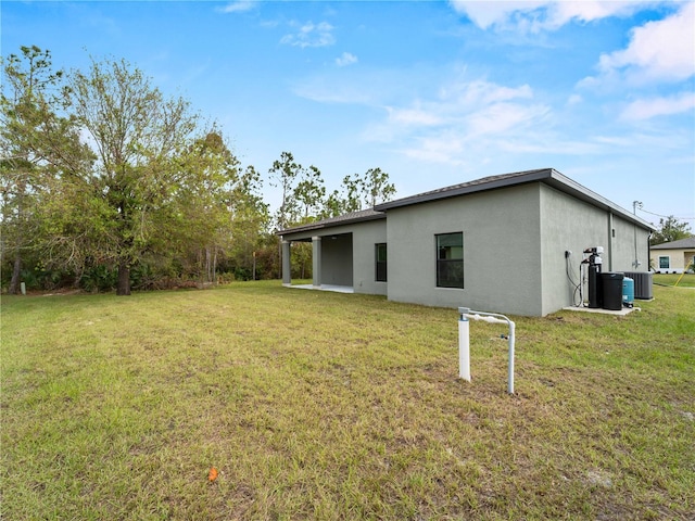 exterior space featuring central air condition unit and a lawn