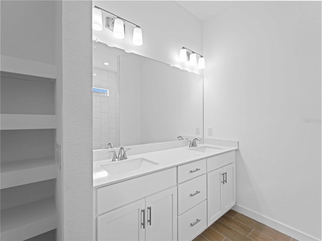 bathroom featuring hardwood / wood-style flooring, vanity, and walk in shower