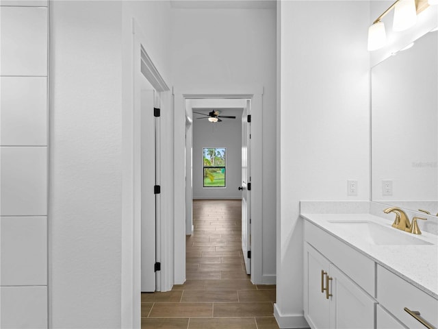 bathroom with hardwood / wood-style floors, ceiling fan, and vanity