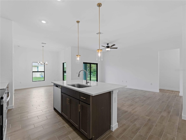 kitchen with stainless steel appliances, a healthy amount of sunlight, sink, and a center island with sink