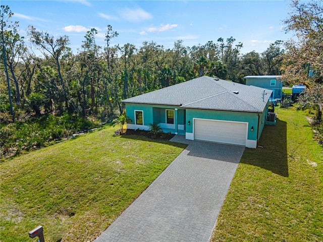 ranch-style home featuring a front yard, cooling unit, and a garage