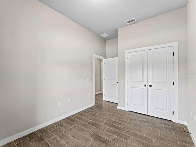 unfurnished bedroom with dark hardwood / wood-style flooring and a closet