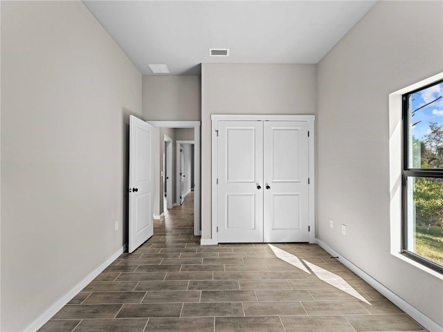 unfurnished bedroom featuring multiple windows, a closet, and dark hardwood / wood-style flooring