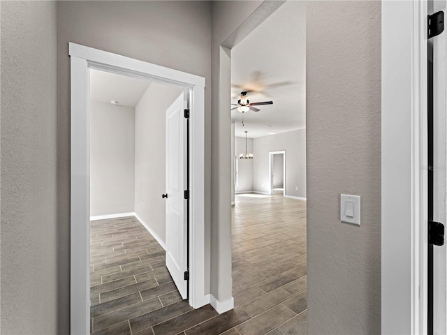 hallway featuring dark wood-type flooring and a chandelier