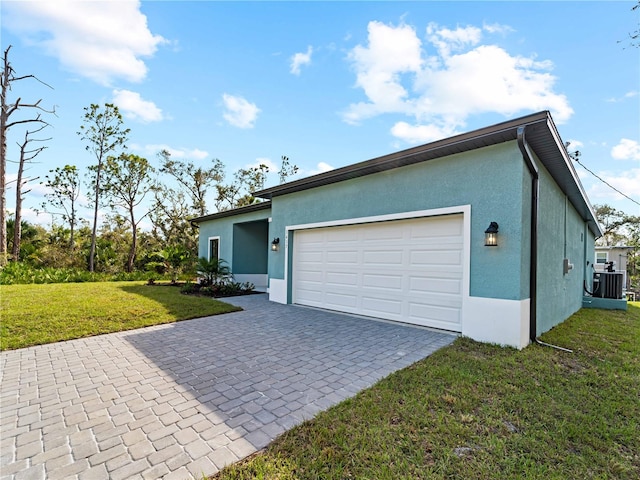 ranch-style house featuring central air condition unit, a garage, and a front yard