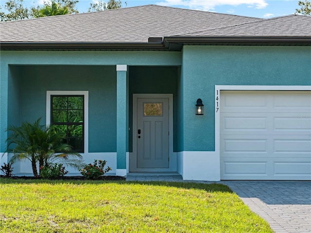 property entrance featuring a garage and a lawn