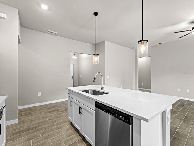 kitchen featuring white cabinetry, stainless steel dishwasher, decorative light fixtures, and sink