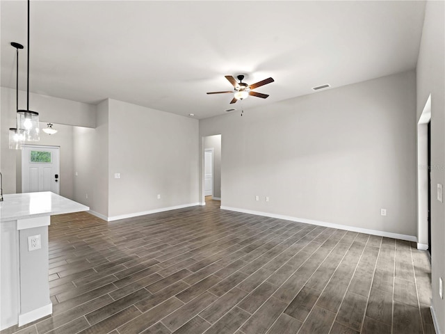 unfurnished living room featuring dark hardwood / wood-style floors and ceiling fan with notable chandelier