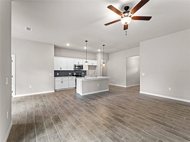 kitchen featuring white cabinets, an island with sink, dark hardwood / wood-style floors, ceiling fan, and pendant lighting