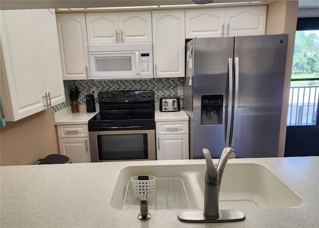 kitchen with white cabinets, stainless steel appliances, and backsplash