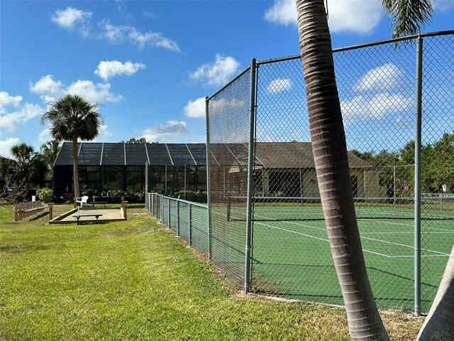 view of sport court with a lawn