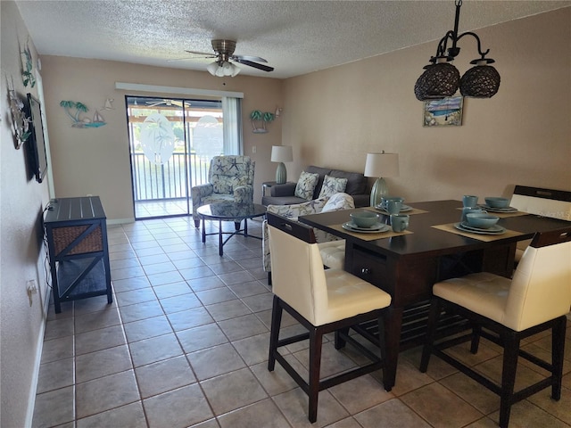 tiled dining space featuring ceiling fan and a textured ceiling