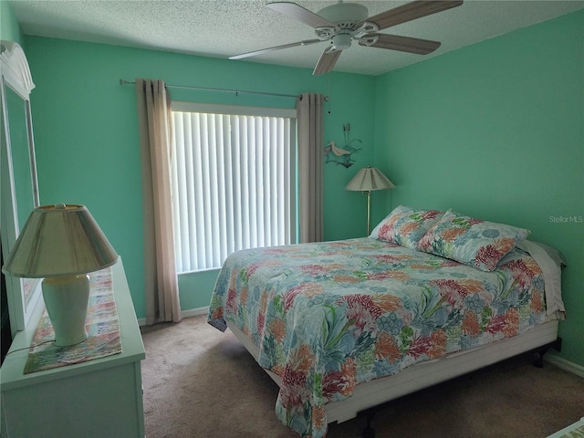 carpeted bedroom featuring ceiling fan, multiple windows, and a textured ceiling