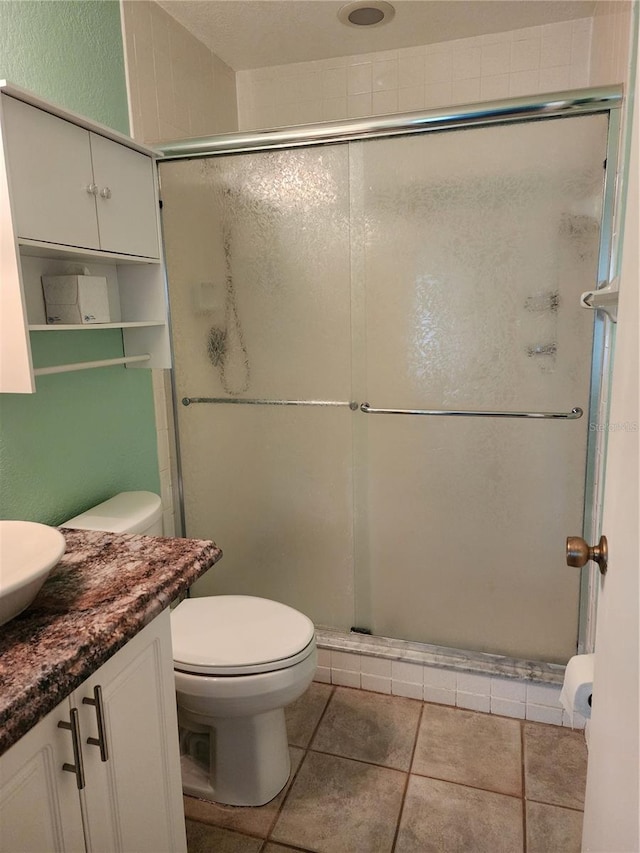 bathroom featuring tile flooring, vanity, an enclosed shower, and toilet