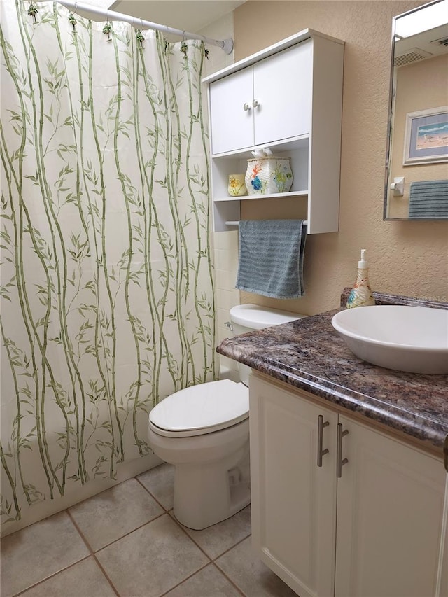 bathroom featuring toilet, tile flooring, and large vanity