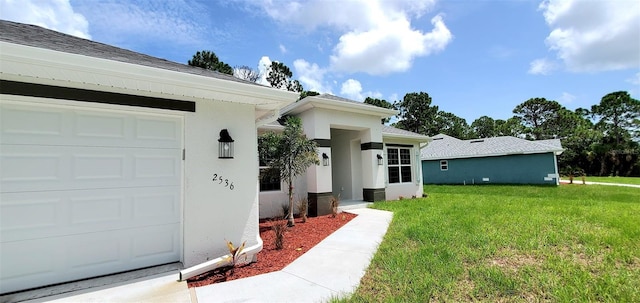 entrance to property with a garage and a yard