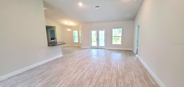 unfurnished room with vaulted ceiling, sink, and light hardwood / wood-style flooring