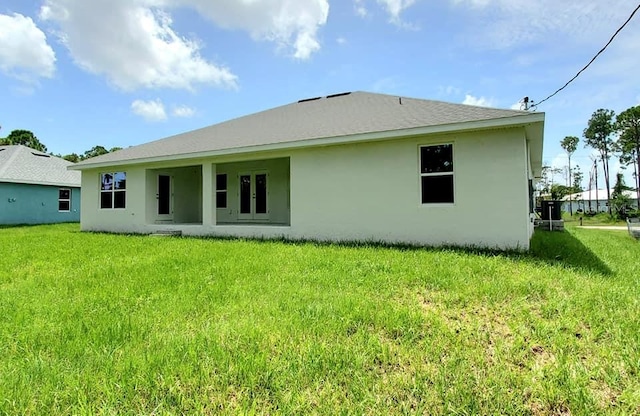 rear view of property with a yard