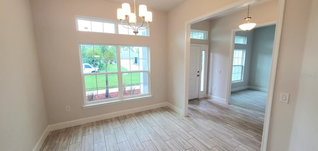 entrance foyer with a notable chandelier and light hardwood / wood-style floors