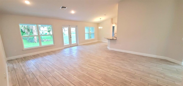 interior space featuring light wood-type flooring, french doors, and lofted ceiling