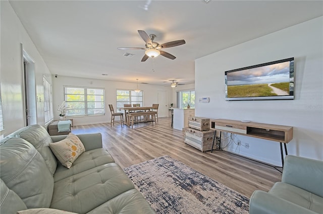 living room featuring light wood-type flooring and ceiling fan