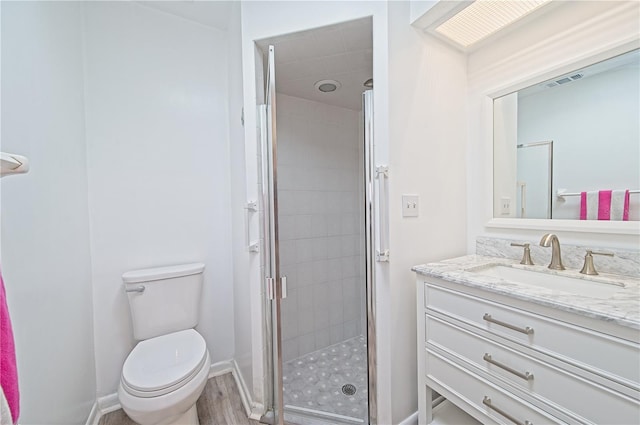 bathroom featuring hardwood / wood-style floors, toilet, an enclosed shower, and vanity