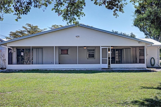 back of house featuring a sunroom and a lawn