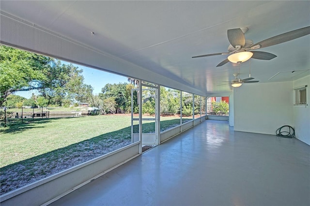 unfurnished sunroom with ceiling fan