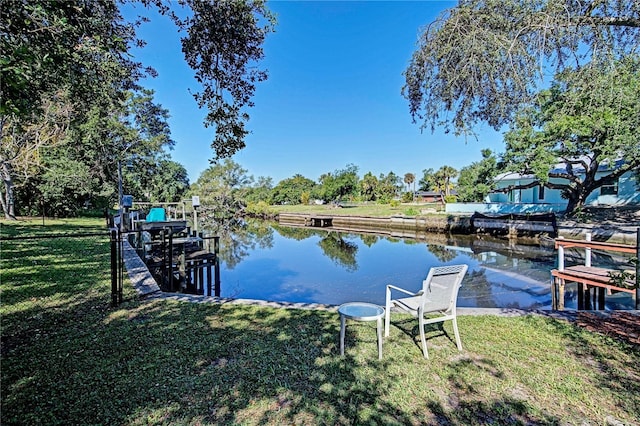 dock area featuring a lawn and a water view