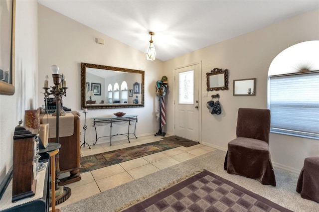 entryway featuring light tile patterned floors and vaulted ceiling