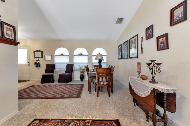 dining area with carpet and lofted ceiling