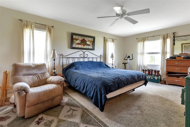 carpeted bedroom featuring multiple windows and ceiling fan