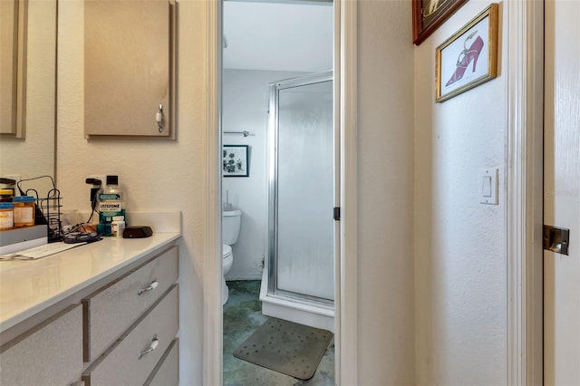 bathroom with tile patterned floors, vanity, toilet, and a shower with door