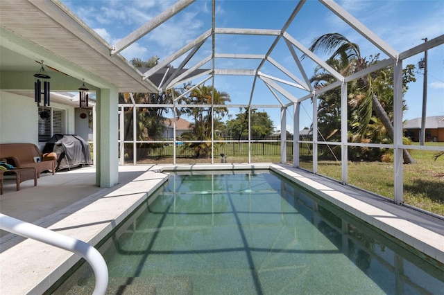 view of pool with glass enclosure, a patio area, and a grill