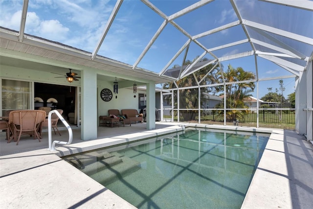 view of swimming pool with ceiling fan, a lanai, an outdoor living space, and a patio