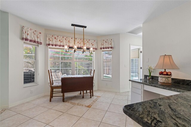 dining room with a chandelier and light tile floors