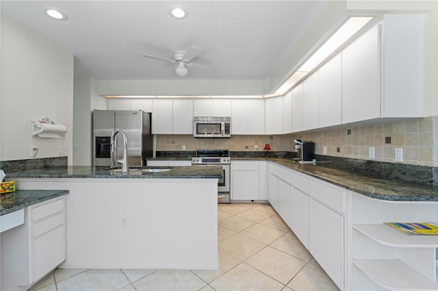 kitchen with dark stone counters, ceiling fan, backsplash, and appliances with stainless steel finishes