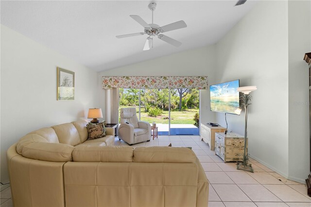 living room with lofted ceiling, ceiling fan, and light tile floors