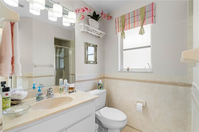 bathroom with tile walls, toilet, and large vanity