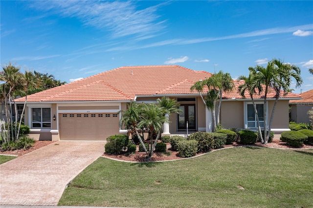 mediterranean / spanish home featuring a front lawn and a garage