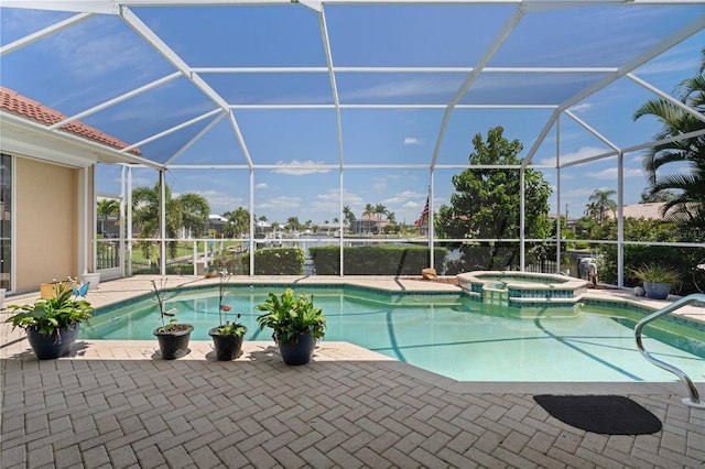 view of pool with an in ground hot tub, glass enclosure, and a patio area