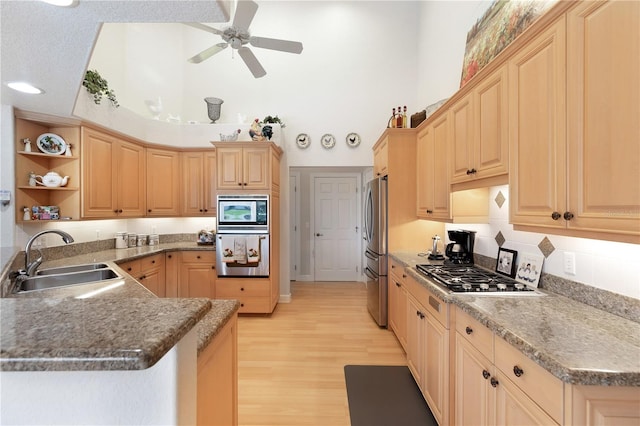 kitchen featuring ceiling fan, stainless steel appliances, sink, kitchen peninsula, and light hardwood / wood-style flooring