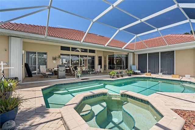 view of swimming pool featuring glass enclosure, an in ground hot tub, and a patio