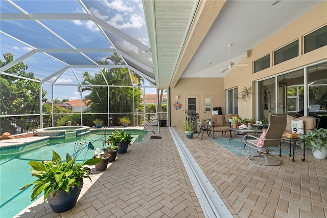 view of swimming pool with ceiling fan, an in ground hot tub, glass enclosure, and a patio