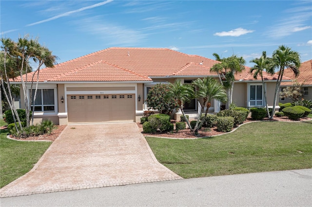 mediterranean / spanish house featuring a front lawn and a garage